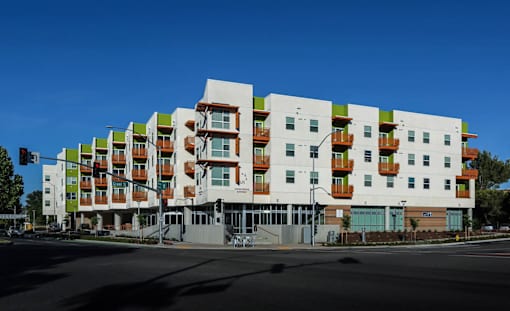 A modern multi-story apartment building with balconies on each floor.