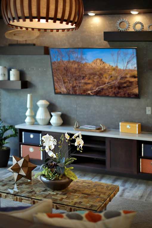 A living room with a flat screen TV mounted on the wall.