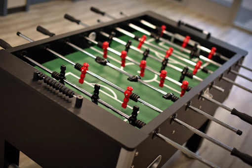 A foosball table with red and black players.