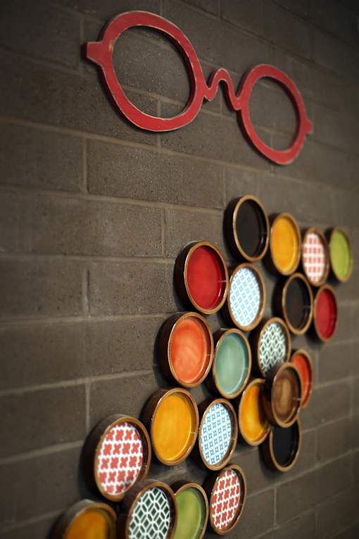 A wall of framed glasses with different colors and patterns.