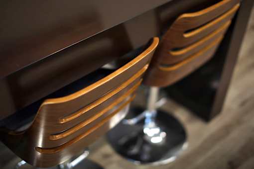 Two brown chairs with metal legs are placed next to a wooden table.