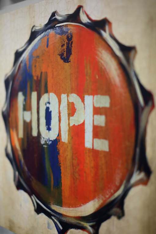 A bottle cap with the word HOPE painted on it.