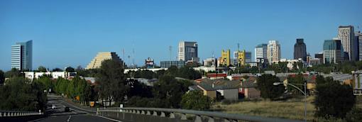 A cityscape with a highway in the foreground.