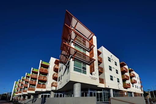A modern building with a white and brown facade and a clear blue sky in the background.