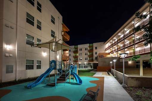 A playground with a blue slide and a green pool.
