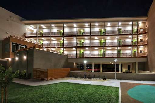 A modern building with a pool in the front yard.