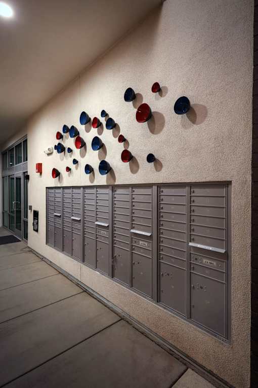 A wall of mailboxes with a row of mailboxes below it.