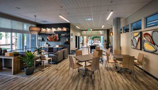 A modern office space with wooden floors and a variety of seating options.