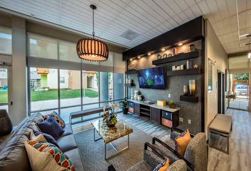 A modern living room with a brown leather couch and a glass coffee table.