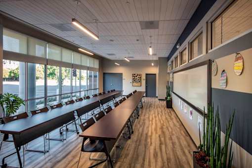 A conference room with a long table and chairs.