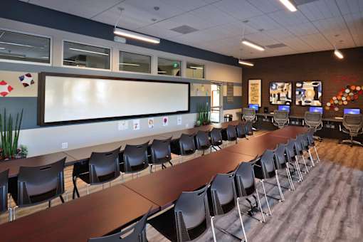 A conference room with a long table and chairs.