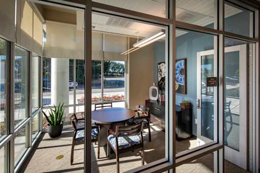 A glass door with a table and chairs in front of it.