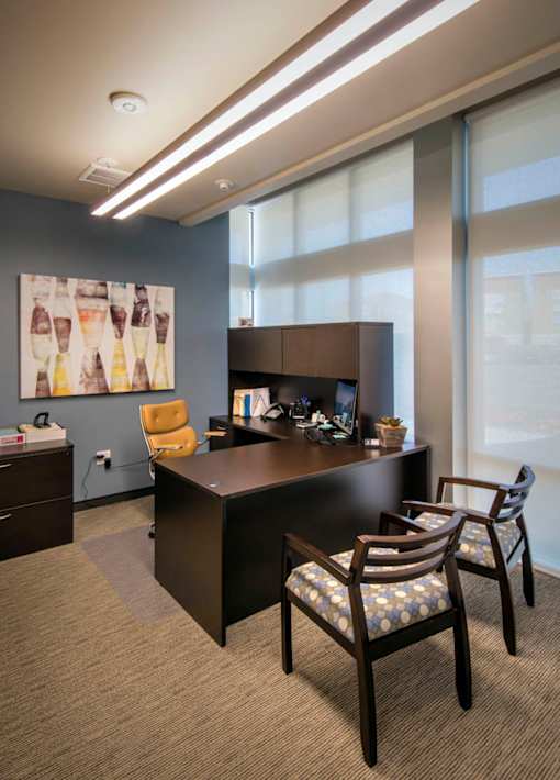 A conference room with a long table and chairs.