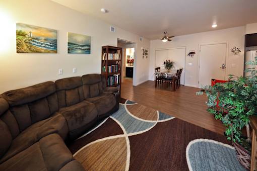 A living room with a large brown couch and a rug.