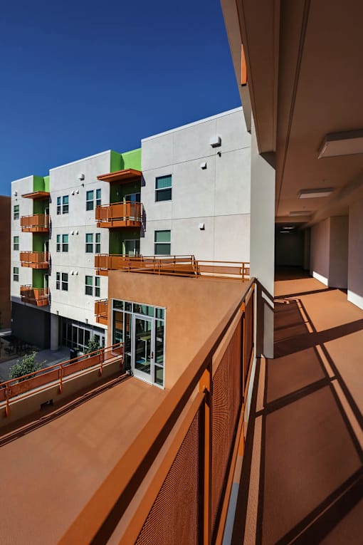 A modern building with a balcony and a clear blue sky.