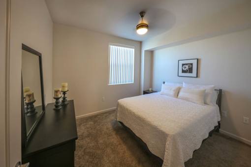 A bedroom with a bed, dresser, and mirror.