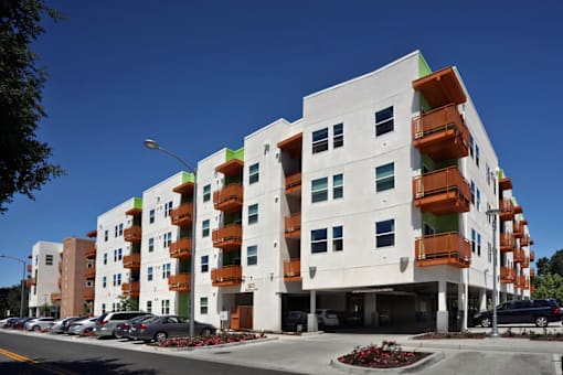 A modern apartment building with white and orange balconies.