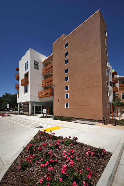 A modern building with a flower bed in front.