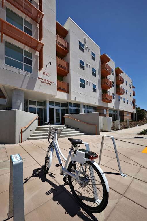 A bicycle is parked on a concrete surface in front of a building.