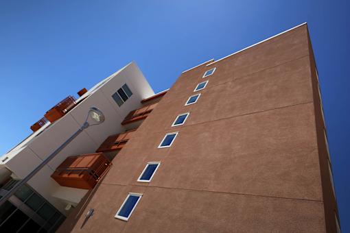 A tall building with a brown facade and white balconies.