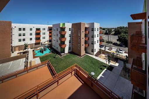 A view of a courtyard from a balcony with a pool.