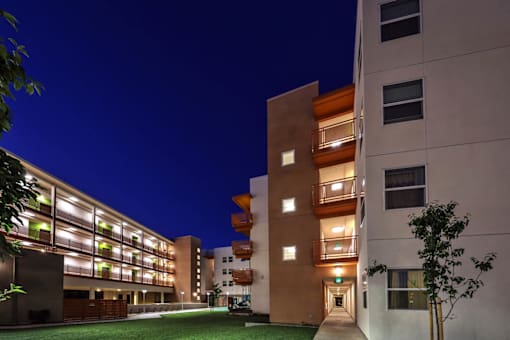 A modern building with a well-lit entrance and balconies.