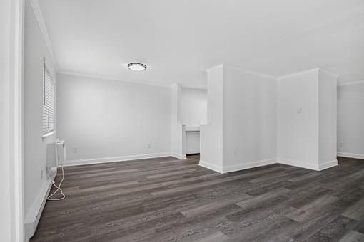 A room with wooden flooring and white walls.