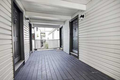 A white house with a black door and a black railing.