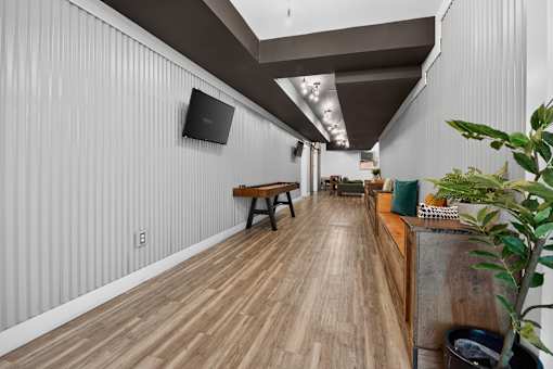 A long hallway with wood floors and a bench.