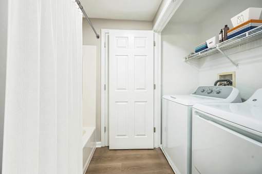 A bathroom with full-size washer and dryer at Birchwood Hills.