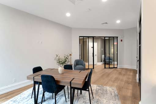 A dining room with a table and chairs.