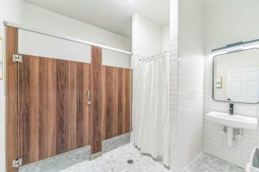 A bathroom with a white sink and a wooden partition.