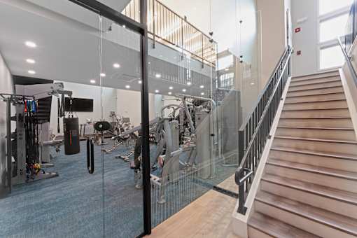 A gym with a staircase and exercise equipment.