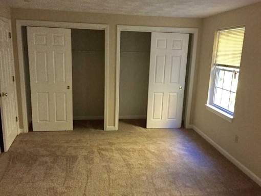 Birchwood Hills Townhomes Bedroom with carpet flooring and two large closets.