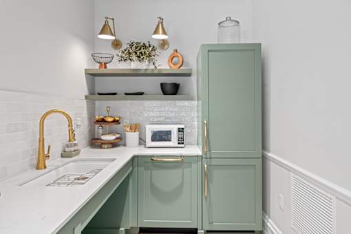 A kitchen with a green cabinet and a white counter.