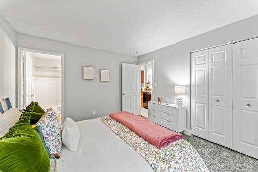 A bedroom with a bed, dresser, and wardrobe.