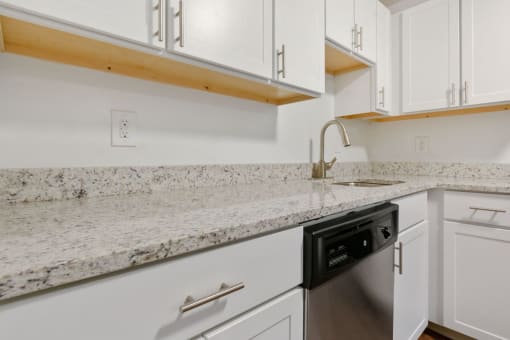 A kitchen with white cabinets and a granite countertop. at South Winds Apartments, Fall River, 02720