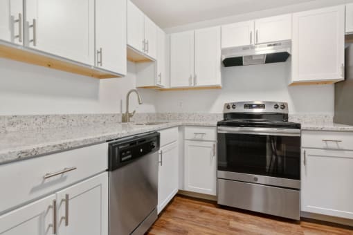 A modern kitchen with white cabinets and stainless steel appliances. at South Winds Apartments, Fall River, 02720