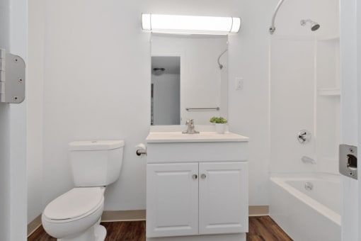 A white bathroom with a toilet, sink, and bathtub. at South Winds Apartments, Massachusetts