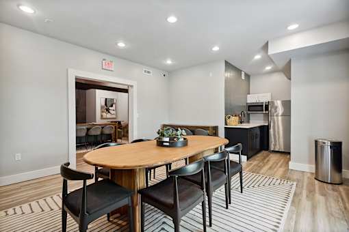 A dining area with a round wooden table and chairs.