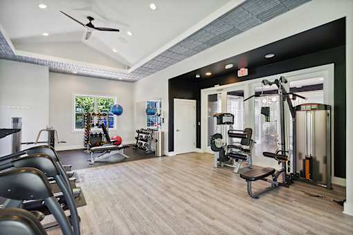 A gym with a variety of equipment including weights and cardio machines.