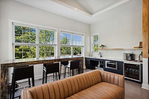 A brown sofa sits in a kitchen with a bar area.