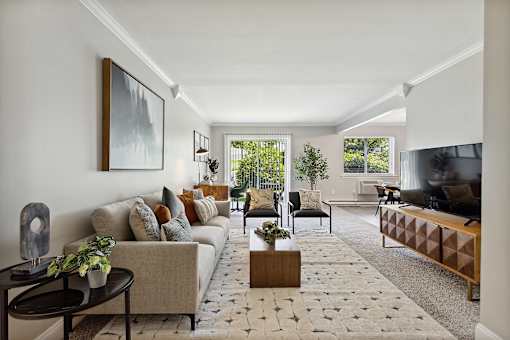 A living room with a couch, coffee table, and a painting on the wall.