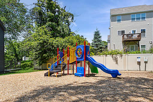 A playground with a blue slide and a red and yellow slide.