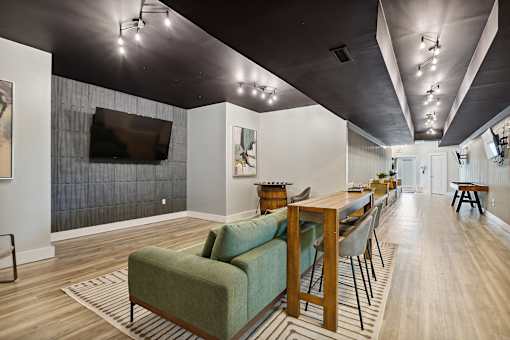 A living room with a green couch and a wooden table.