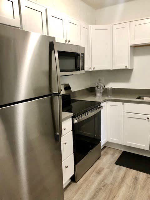 a kitchen with stainless steel appliances and white cabinets