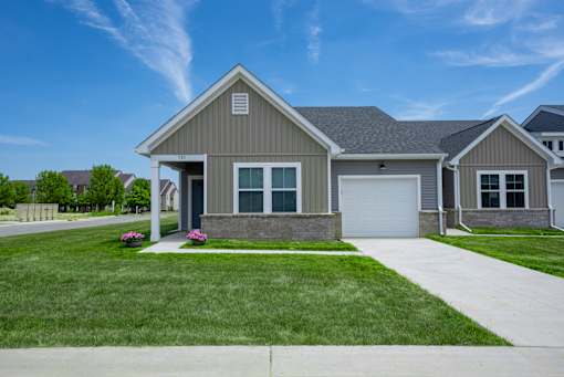 A house with a grey roof and a white garage door.