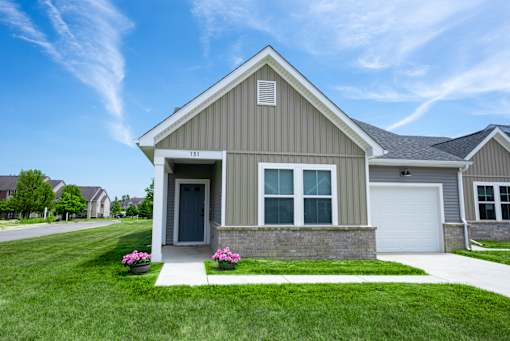 A house with a grey facade and a white garage door.
