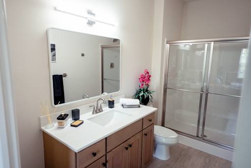 A bathroom with a white counter top and a white toilet.