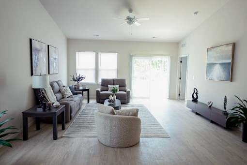 A living room with a grey sofa, a white armchair and a coffee table.